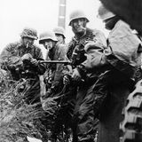 Kampfgruppen Hansen in der Ardennenoffensive bei Poteau. Der Schütze in der Mitte trägt das MG und Gurte. 