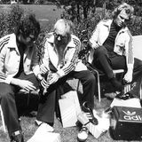 Vor der WM 1974 probieren Libero und Kapitän Franz Beckenbauer (l.) und Mittelfeldspieler Uli Hoeneß (r.) Fußballschuhe an, die Adidas-Gründer Addi Dassler (M.) persönlich in der Sportschule Malente (Schleswig-Holstein) abliefert.