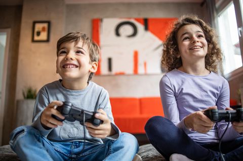 Zwei Kinder spielen an einer Spielkonsole