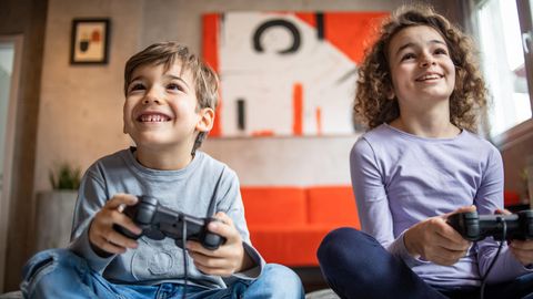 Zwei Kinder spielen an einer Spielkonsole