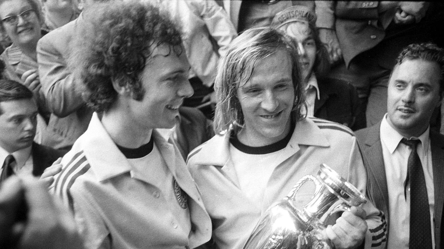 Den Pokal für die Europameisterschaft 1972 nehmen Franz Beckenbauer und Günther Netzer in ihren Adidas-Trainingsjacken entgegen