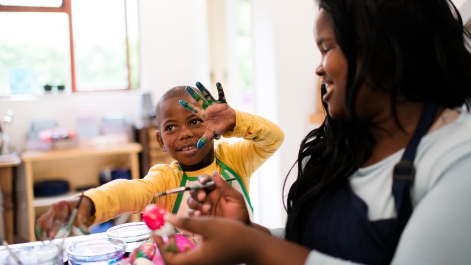 Kind bemalt mit Frau Ostereier