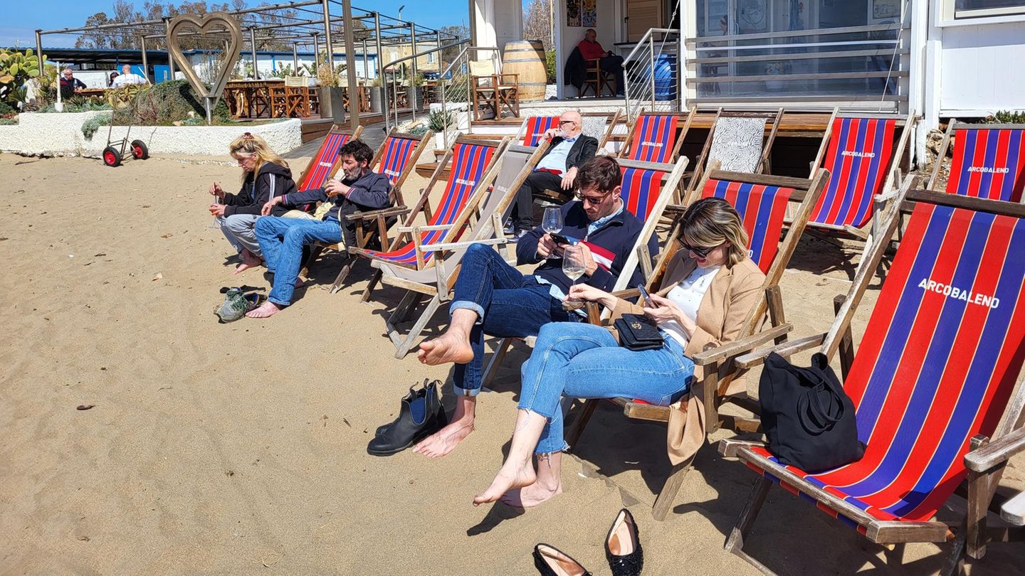 Gäste am Strand Gäste feiern den Saisonbeginn mit Prosecco oder Aperol Spritz