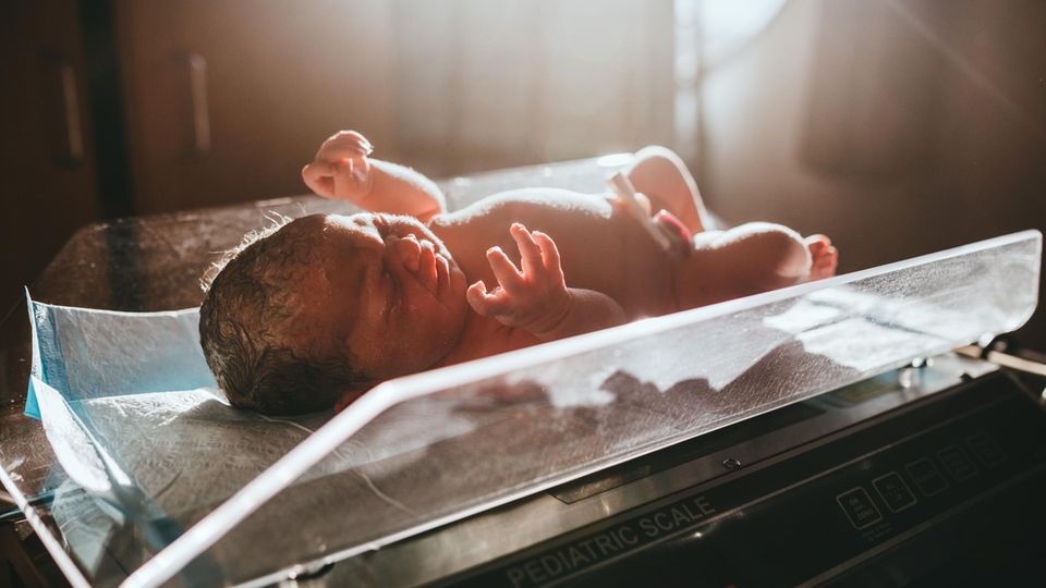 Ein Baby, das gerade im Krankenhaus geboren wurde, wird auf eine Waage gelegt