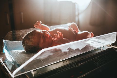 Ein Baby, das gerade im Krankenhaus geboren wurde, wird auf eine Waage gelegt