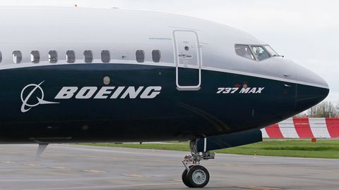 Ein Pilot winkt aus der Pilotenkabine eines Flugzeuges vom Typ Boeing 737 MAX 9 auf dem Flughafen.