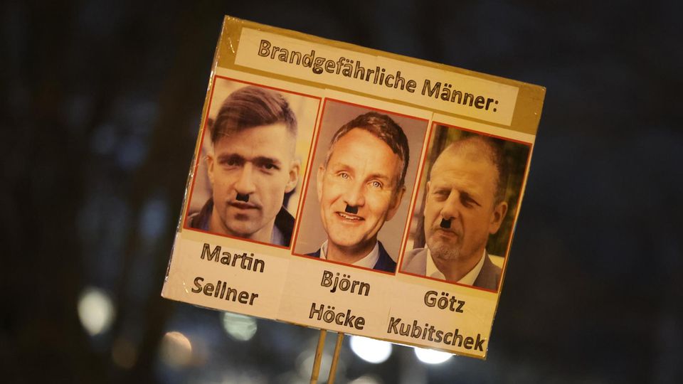 Ein Plakat, auf dem Martin Sellner, Björn Höcke und Götz Kubitschek mit Hilterbart zu sehen sind