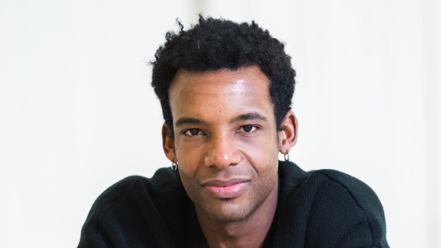 Osiel Gouneo schaut in die Kamera, er trägt ein dunkles Hemd und einen schwarzen, kurzen Afro Osiel Gouneo schaut in die Kamera, er trägt ein dunkles Hemd und einen schwarzen, kurzen Afro