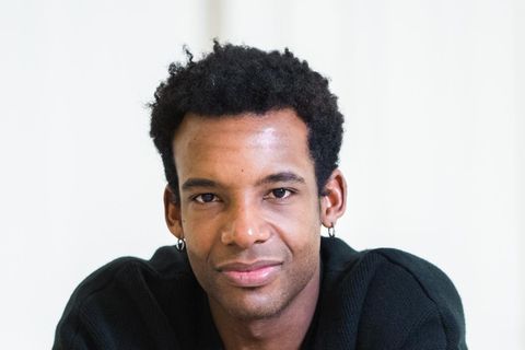 Osiel Gouneo schaut in die Kamera, er trägt ein dunkles Hemd und einen schwarzen, kurzen Afro
