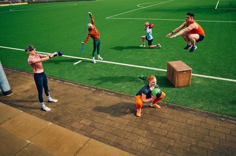 Mehrere Personen bei unterschiedlichen Übungen auf einer Sportanlage