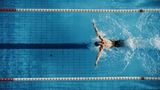 Ein Mann schwimmt "Brustschwimmen" in einem Sportschwimmbecken.