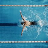 Ein Mann schwimmt "Brustschwimmen" in einem Sportschwimmbecken.