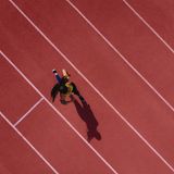 Läuferin hört Musik und läuft auf einer Sportbahn