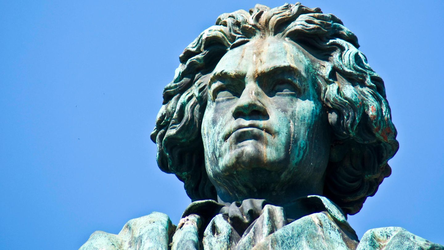 Der Kopf einer Beethoven-Statue aus Bronze ragt in den blauen Himmel.