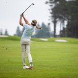 Eine Golfspielerin schlägt mit ihrem Schläger nach dem Golfball auf dem Platz.