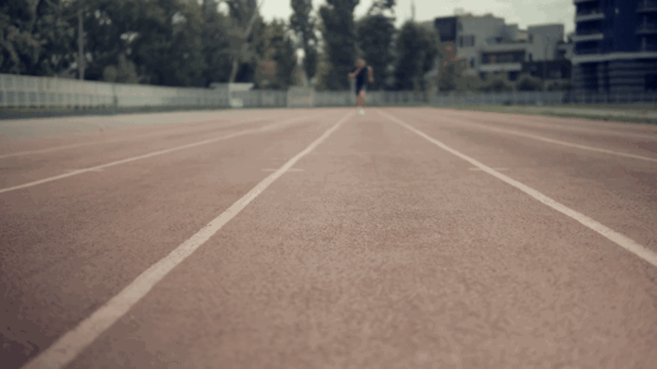 Fitness Ein Mann sprintet auf einer Rennbahn