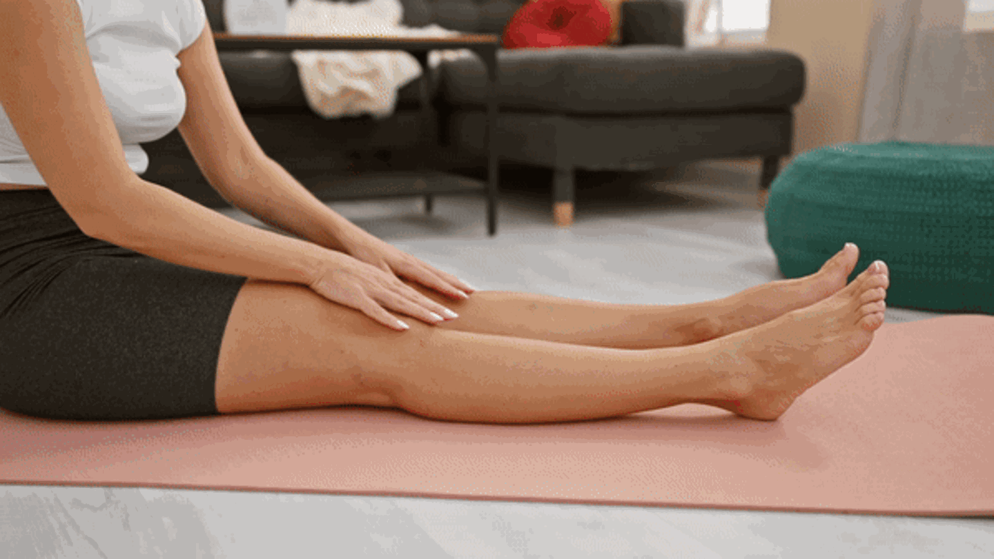 Eine Frau führt eine Sitzende Vorbeuge durch