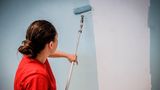 Eine Malerin streicht eine Wand