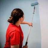 Eine Malerin streicht eine Wand