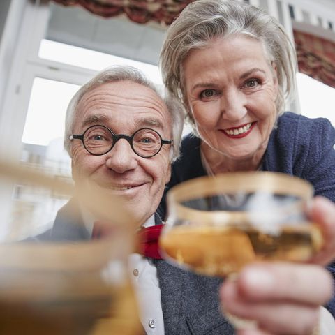 Elderly couple clink glasses without thinking about their heirs and children