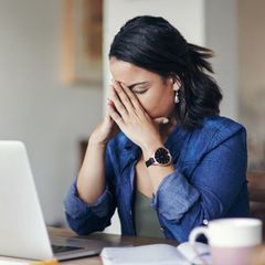 Eine Frau sitzt ratlos am Laptop