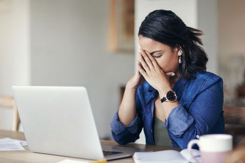 Eine Frau sitzt ratlos am Laptop