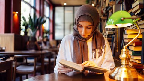 Eine junge Muslima in einer Bibliothek
