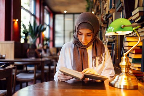 Eine junge Muslima in einer Bibliothek