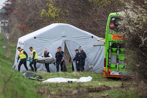Bestatter tragen ein Todesopfer des verunglückten Busses von der Unfallstelle auf der A9 bei Leipzig