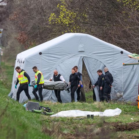 Bestatter tragen ein Todesopfer des verunglückten Busses von der Unfallstelle auf der A9 bei Leipzig
