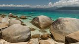 Wunderschöner weißer Nudey Beach mit Touristen, Schnorchlern und vorbeifahrenden Segelbooten