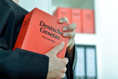 Ein Mann hält eine Gesetzessammlung in den Händen