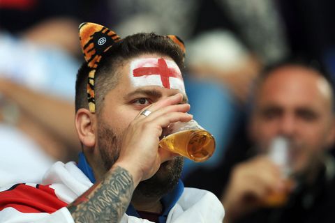 Ein England-Fan trinkt im Stadion ein Bier
