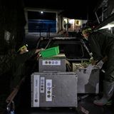 Auf der Ladefläche eines Truck bereiten zwei Mitarbeiter im Dunkeln Fressen für die Tiere vor