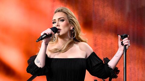 Adele sing auf der Bühne mit knallrotem Hintergrund
