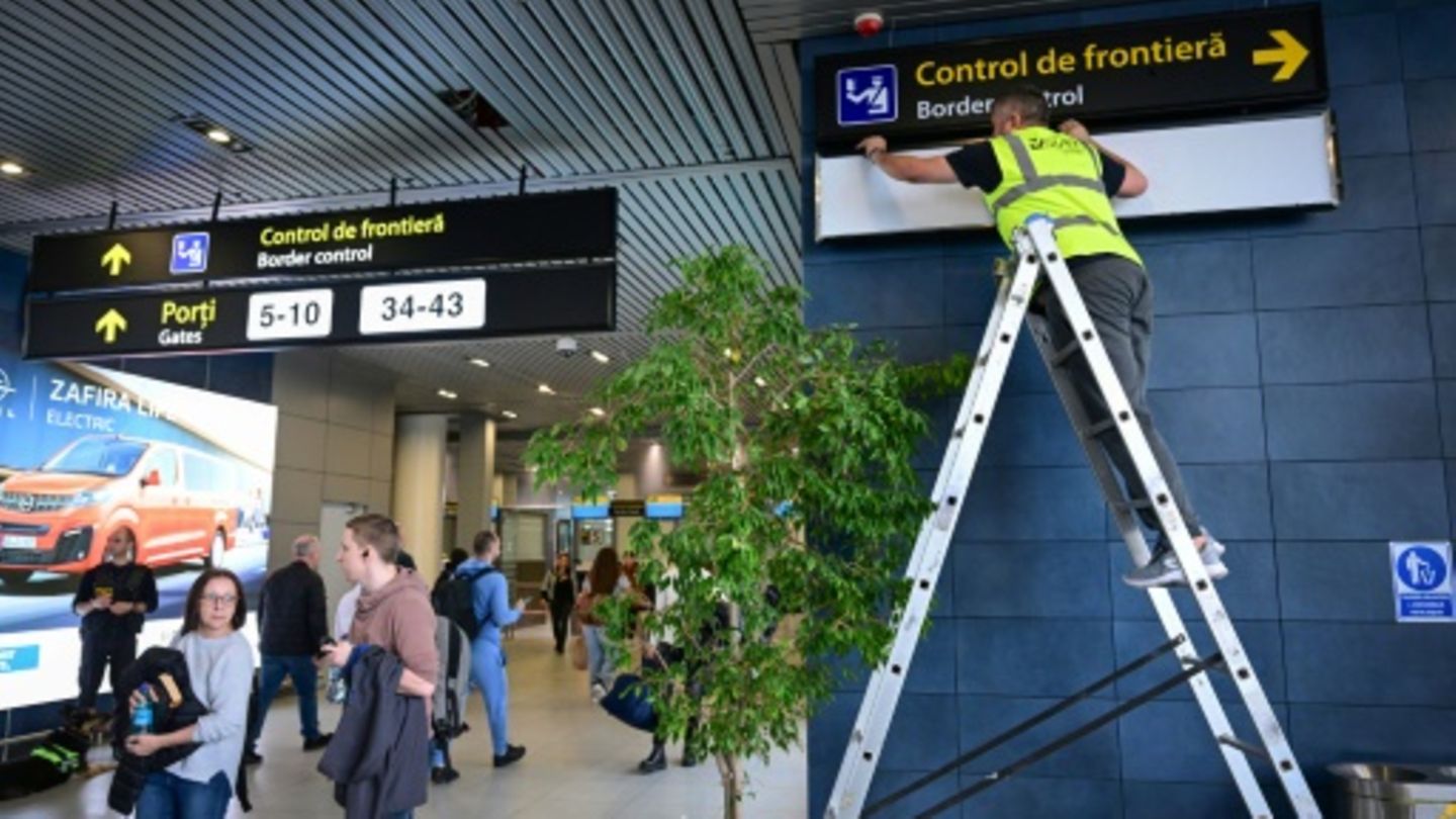 Ein Arbeiter ändert Schilder am Flughafen von Bukarest