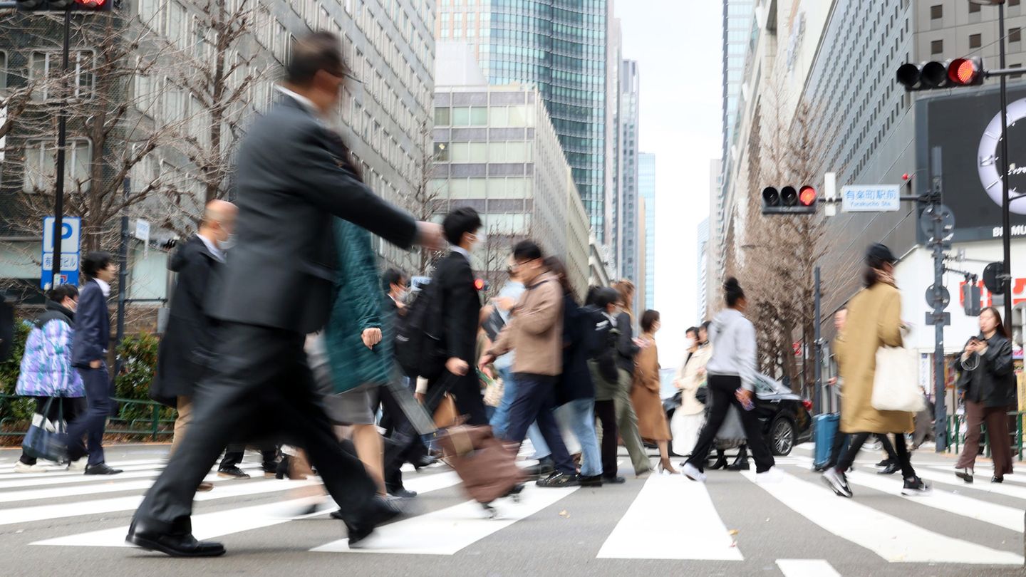 Japan: Menschen gehen in Tokio über eine Kreuzung