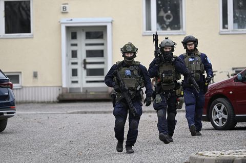 Drei Polizisten verlassen eine Grundschule in Finnland
