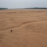 Fischer läuft durch ausgetrocknetes Flussbett