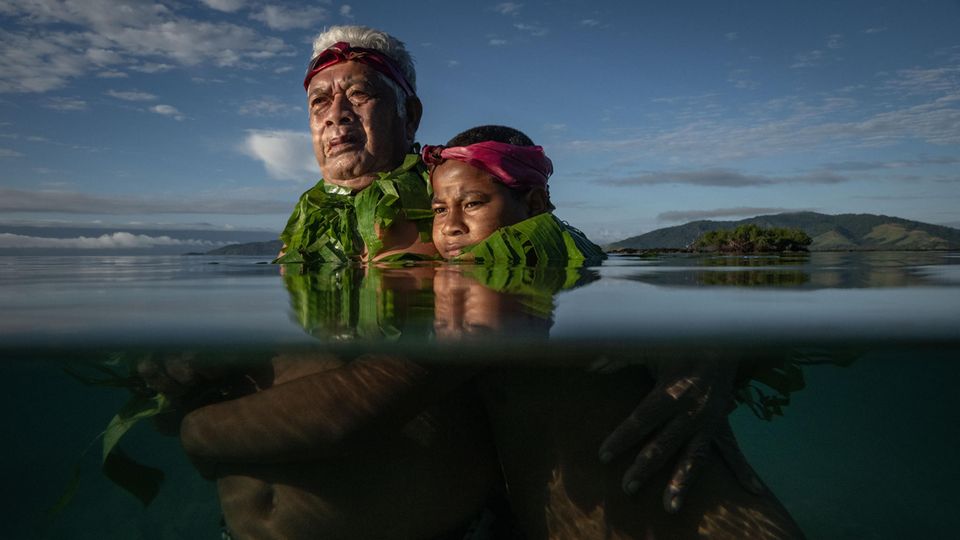 Lotomau Fiafia und sein Enkel stehen im Wasser