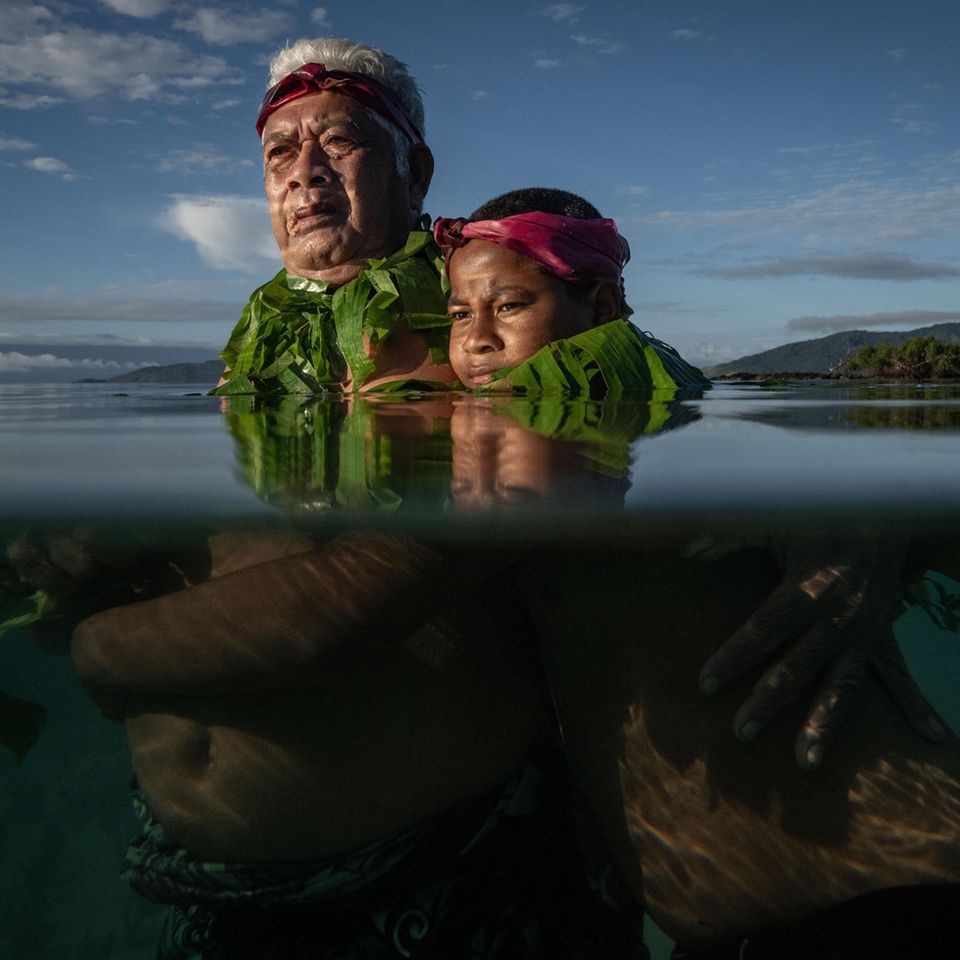 Lotomau Fiafia und sein Enkel stehen im Wasser