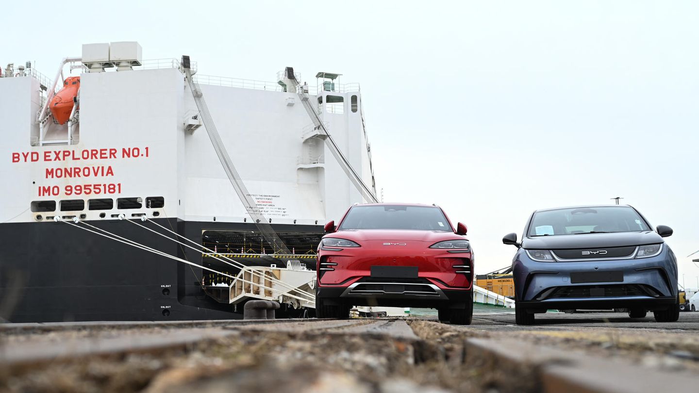 Zwei Neuwagen des chinesischen Automobilherstellers BYD stehen vor dem Autofrachter BYD Explorer No.1" in Bremerhaven