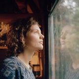 Die Aktivistin "Indigo" schaut aus einem Fenster eines Baumhauses.