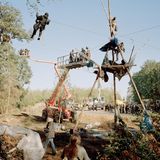 Aktivisten haben sich in luftiger Höhe auf einem Podest verschanzt und warten darauf von der Polizei herunter geholt zu werden.