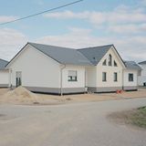 Das Bild zeigt ein neues Haus für umgesiedelte Menschen aus dem betroffenen Dörfern des Braunkohletagebaus.