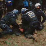 Polizisten nehmen einen Aktivisten fest, der am Boden liegt.