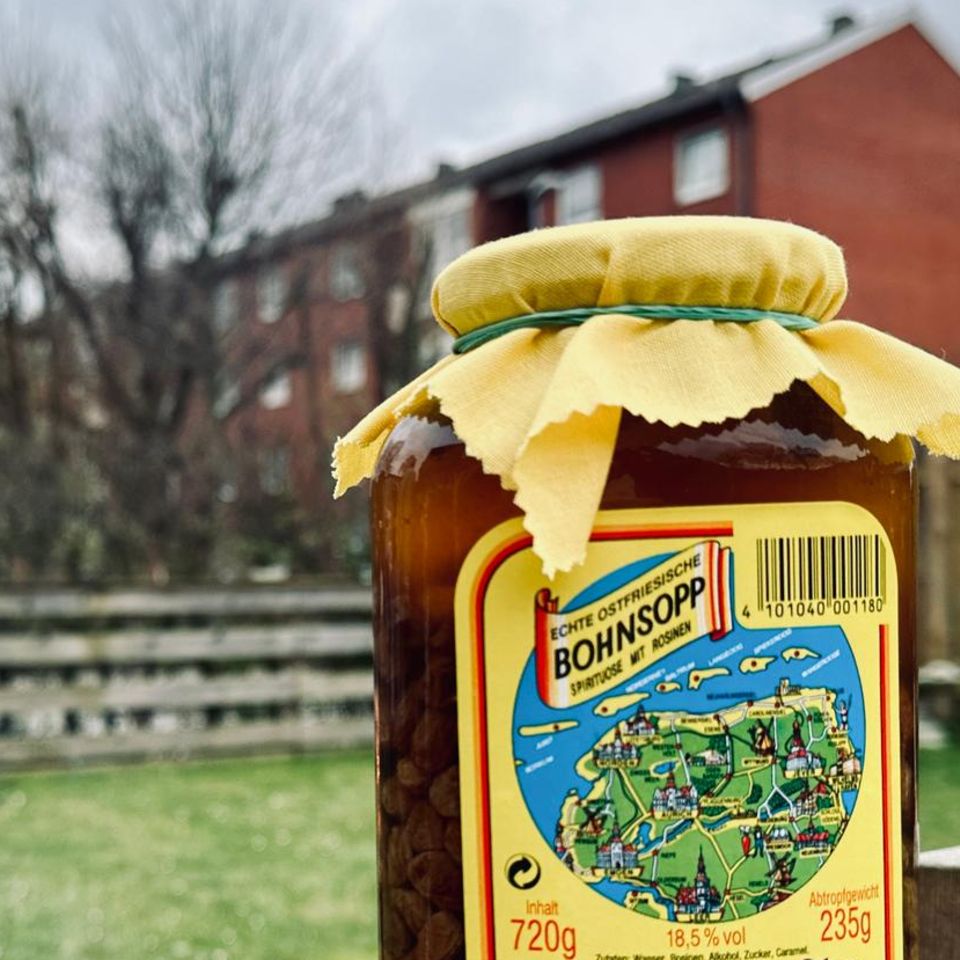 Ein Glas ostfriesische Bohnsopp steht vor einem brennenden Feuerkorb.