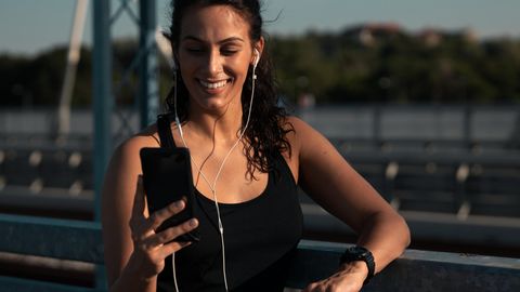 Frau treibt Sport mit Smartphone Google Pixel 8 Pro und Fitnesstracker.