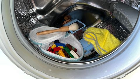 Lego reinigen: Legosteine liegen im Wäschesack in einer Waschmaschine