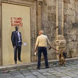 Ein Graffiti von Falcone. Davor steht ein Mann mit Hund